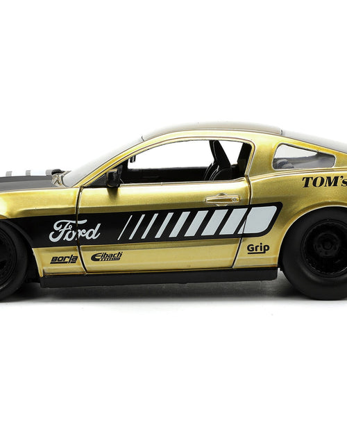 Load image into Gallery viewer, 2010 Ford Mustang GT Gold Metallic with Black Graphics and Hood "Tom's Racing" "Bigtime Muscle" Series 1/24 Diecast Model Car by Jada
