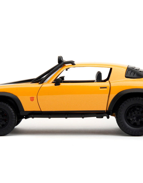 Load image into Gallery viewer, 1977 Chevrolet Camaro Off-Road Version "Bumblebee" Yellow Metallic with Black Stripes and Transformers Logo Diecast Statue "Transformers: Rise of the Beasts" (2023) Movie "Hollywood Rides" Series 1/24 Diecast Model Car by Jada
